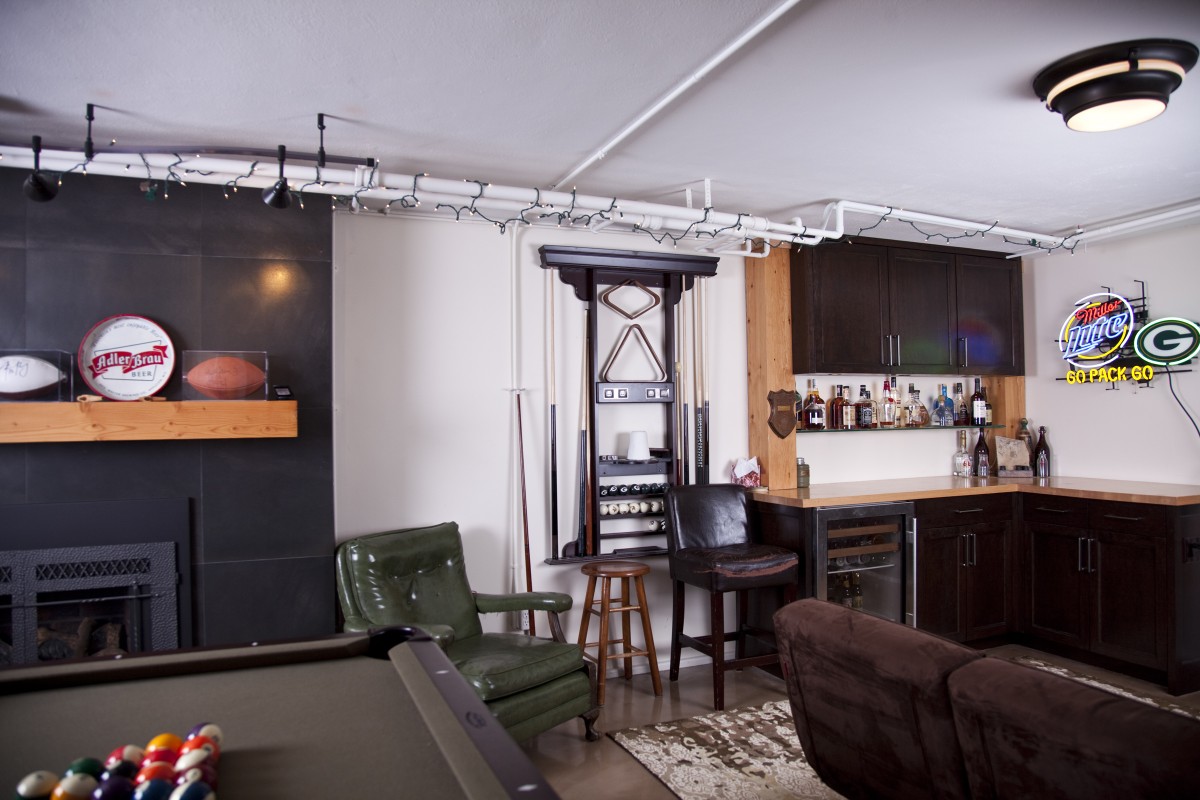 <p>After the main project was finished, the owners hired TreHus to come back and remodel a room in the basement.  It now features a stained concrete floor, a new bar with dark-stained cherry cabinets, reclaimed fir posts and counter top, a remodeled fireplace, and new shelves for the owner’s beer can collection.</p>
