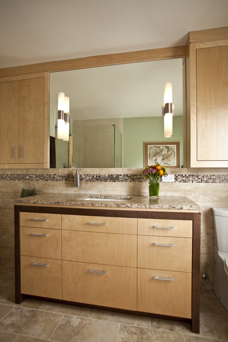 <p>This bathroom includes plenty of storage in the vanity and in built-in cabinets on either side of the vanity. All of the cabinetry is maple, with the two tones in the vanity being achieved by staining (which you know is not easy if you have ever tried to stain maple). A decorative tile band runs all the way around the bathroom.</p>
