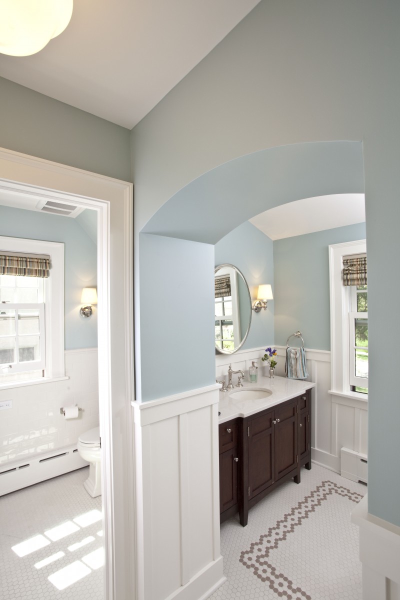 <p>This bathroom is used every morning by a busy family of six as they get ready for the day. Popping up a dormer made the bathroom much larger, and light finishes give the room a clean, cheery feeling. Details like the white painted wood wainscoting and rug inlay add visual interest, while the dueling vanities make it easy for several people to get ready for the day simultaneously.</p>
