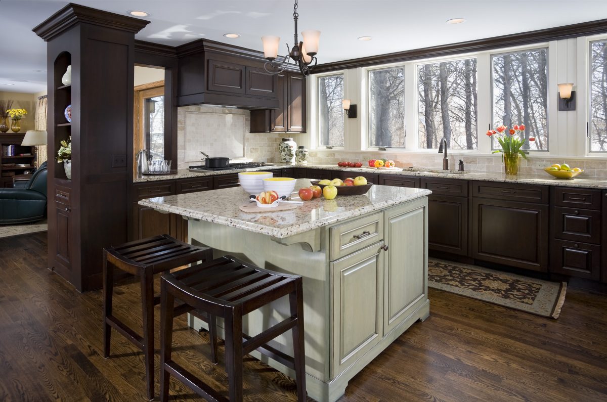 <p>In the kitchen, honey oak cabinets were replaced by dark-stained custom cherry perimeter cabinets and a pigment stained island.  A small addition made the kitchen more spacious, and large new windows provide panoramic views of the wooded lot.</p>

