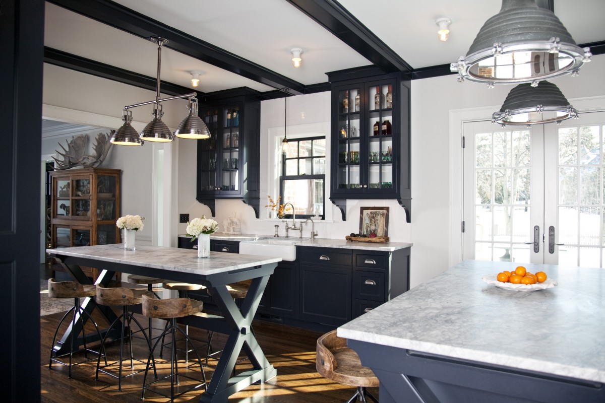 <p>This kitchen’s black and white color palette, industrial light fixtures and the owners’ unique decorating style combine to striking effect. The kitchen was opened up to the dining area to create better flow in the home’s interior, and new french patio doors connect it to the outdoors.</p>
