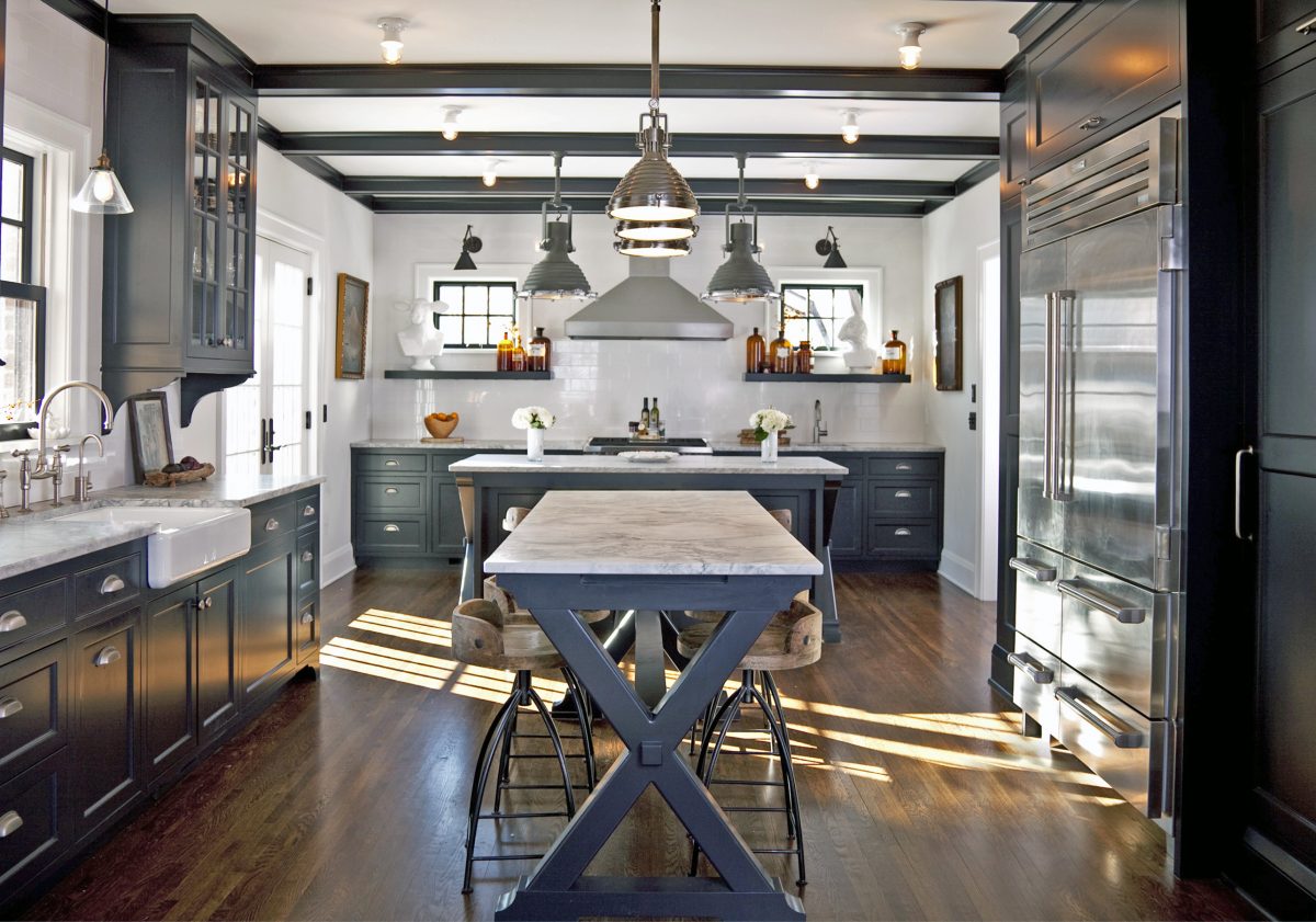 <p>This kitchen’s black and white color palette, industrial light fixtures and the owners’ unique decorating style combine to striking effect. The kitchen was opened up to the dining area to create better flow in the home’s interior, and new french patio doors connect it to the outdoors.</p>
