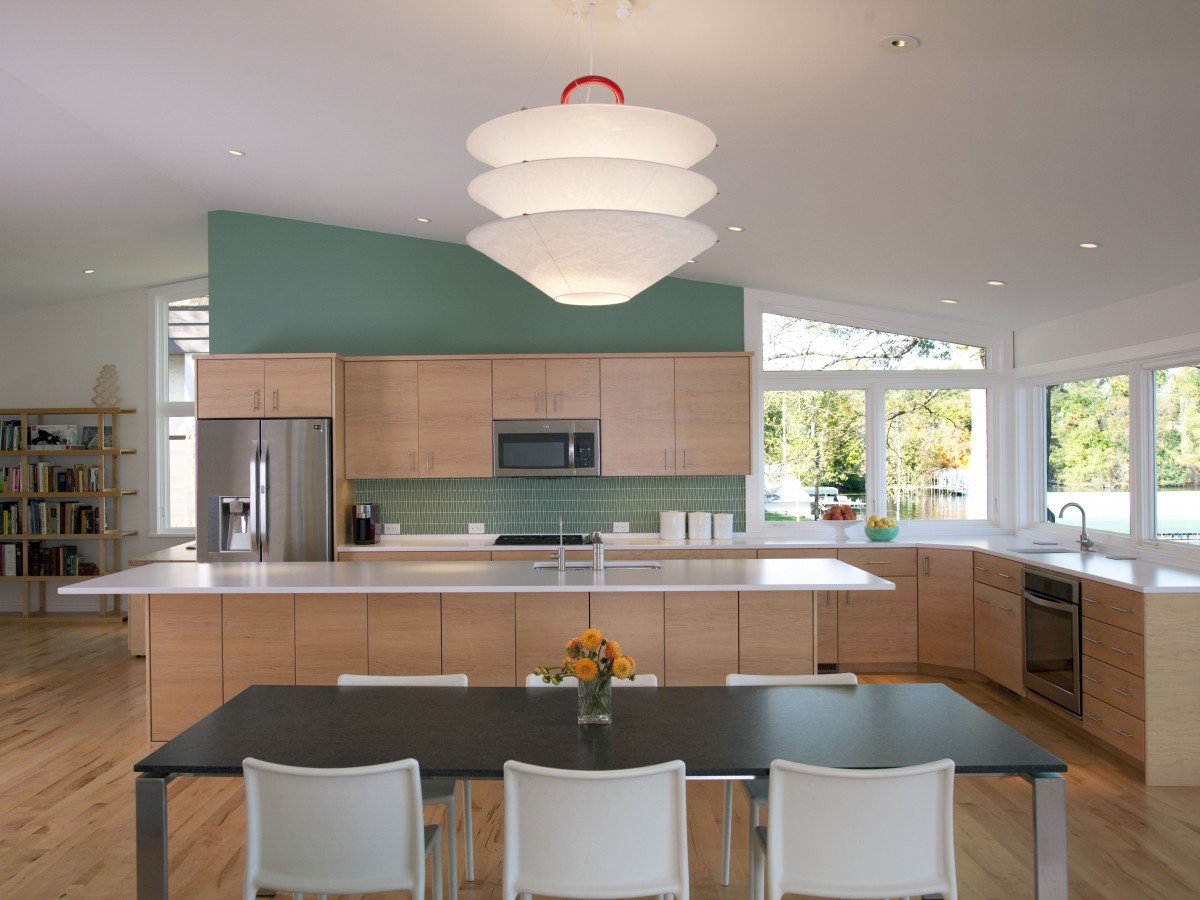 <p>The kitchen was designed to take full advantage of the beautiful view. The aqua wall, matching backsplash tile and light maple cabinetry echo the home’s tranquil lakeshore feeling.</p>
