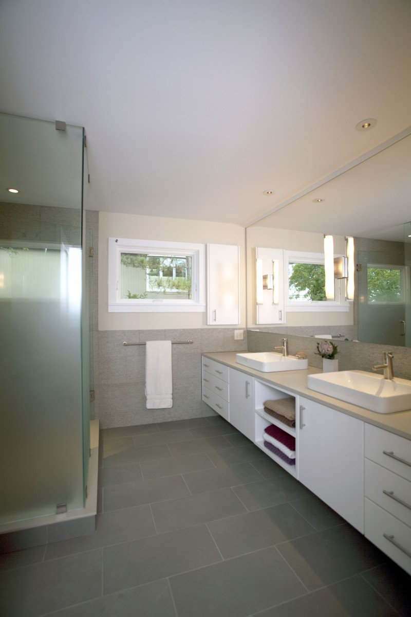 <p>The bathrooms feature clean design and a relaxed color palette, working in harmony with the rest of the home. The master bathroom’s shower was installed with gradient-frosted glass for privacy.</p>
