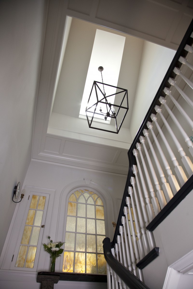 <p>Opening the floor beneath a dormer at the main stairwell increased the amount of daylight coming into the house. A paneled ceiling was created to highlight and frame the new opening to the dormer above.</p>

