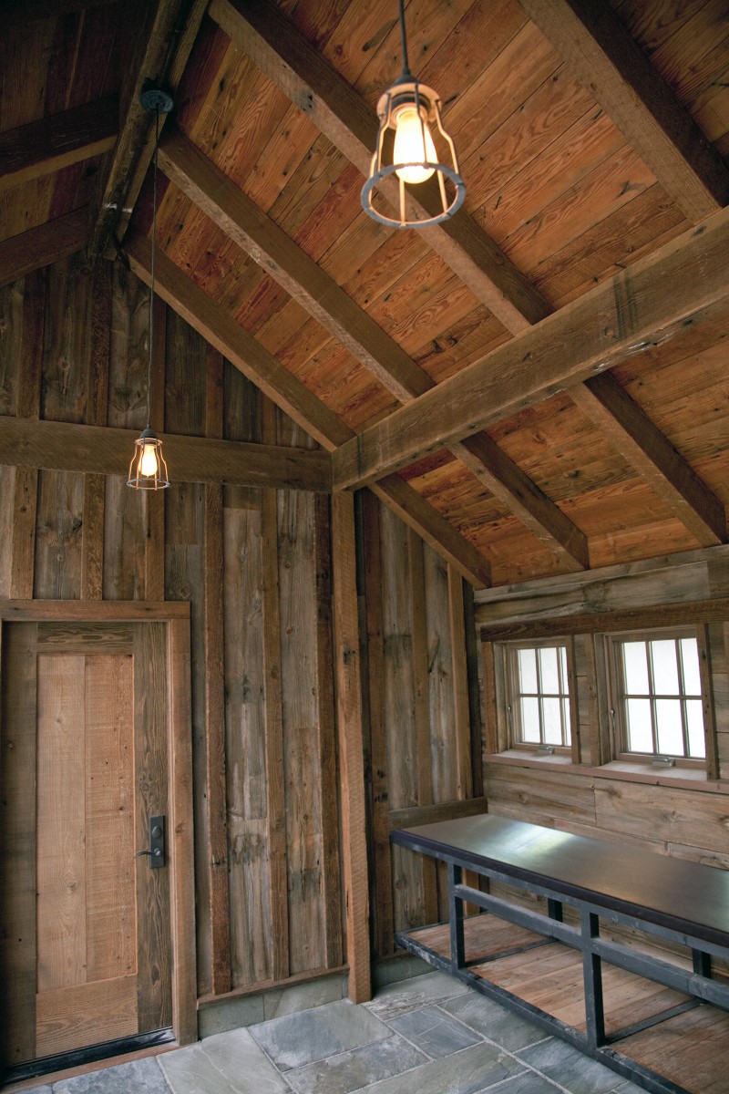 <p>Rustic sophistication aptly describes this new garage and timber frame breezeway. Board and batten siding was crafted from antique reclaimed wood shipped from Montana. Stone slab steps lead to bluestone pavers, which continue onto a pergola-covered patio.</p>
