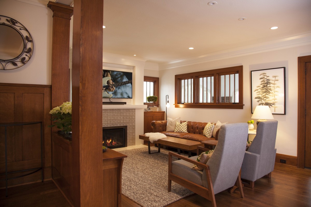 <p>The home’s interior was transformed to reflect more of the family’s personal style. A mix of soft colors, textures, and bold patterns in the living room enhance the quartersawn oak trim and the client’s collection of Arts and Crafts furniture. Large unused doors leading to the porch were replaced with high windows, allowing for a more functional seating arrangement.</p>
