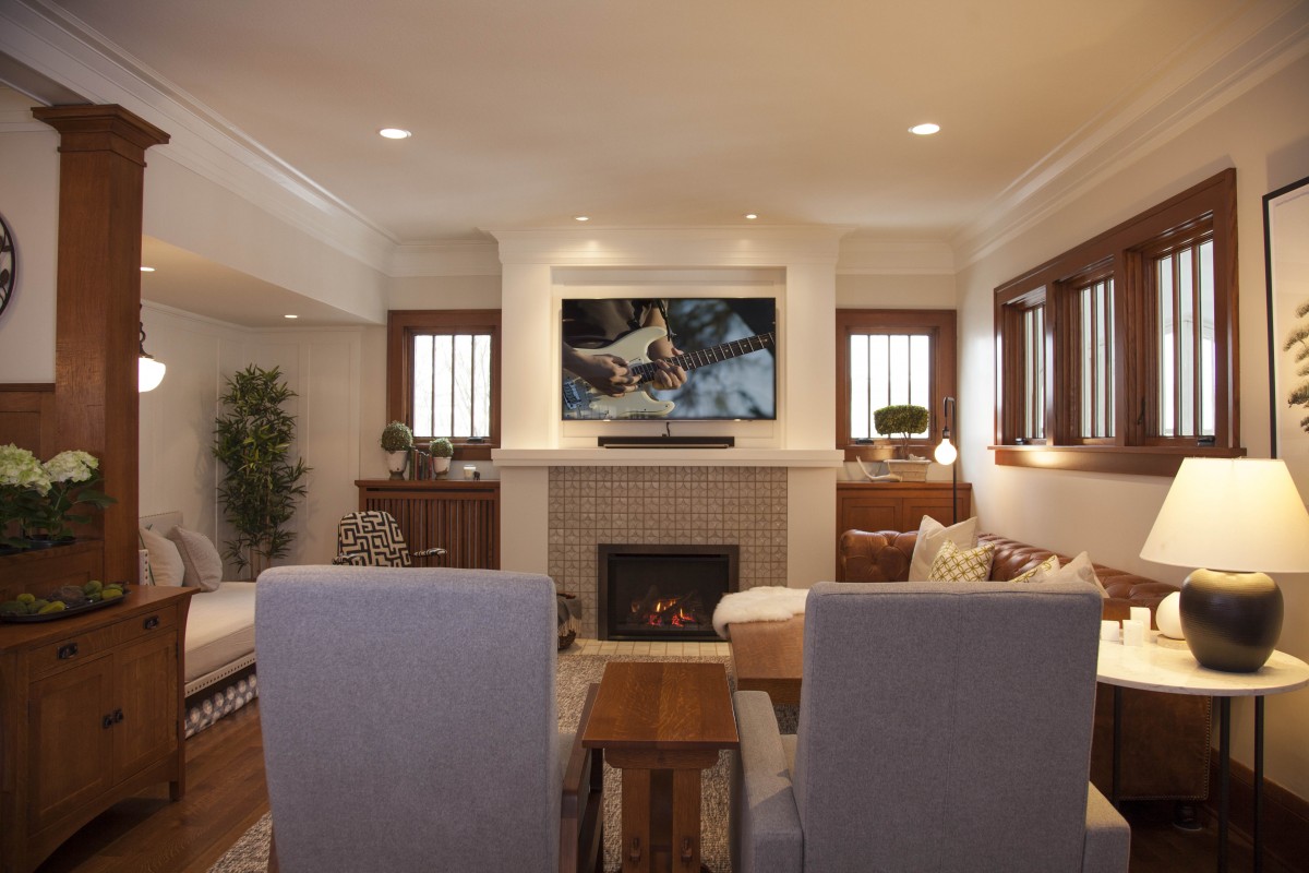 <p>The home’s interior was transformed to reflect more of the family’s personal style. A mix of soft colors, textures, and bold patterns in the living room enhance the quartersawn oak trim and the client’s collection of Arts and Crafts furniture. Large unused doors leading to the porch were replaced with high windows, allowing for a more functional seating arrangement.</p>
