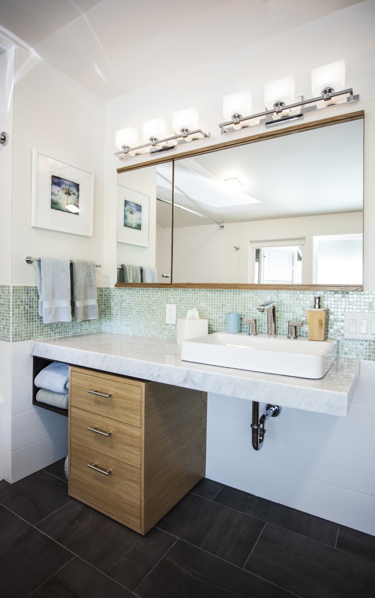 <p>The original gray and white finishes of this bathroom were enlivened by a colorful deco tile, and warm, rift cut oak.  The cantilevered marble counter creates an accessible vanity while staying true to the modern architectural form of the home.</p>
