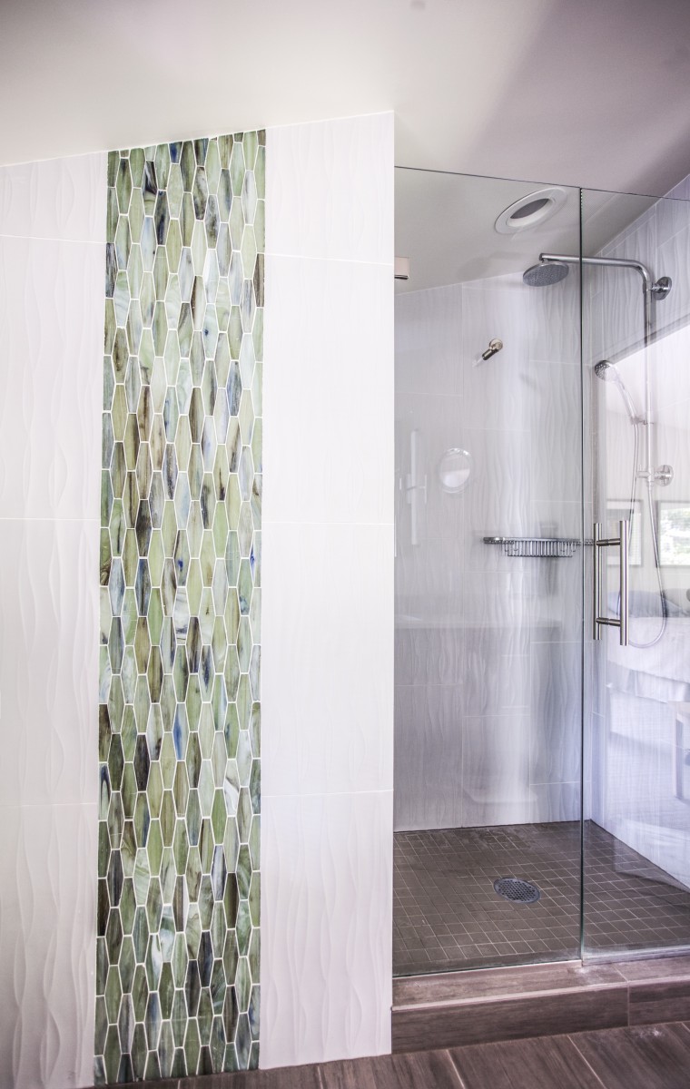 <p>The fixtures in this master bath were rearranged to create space for the shower that was lacking from the original.  A blend of textured and glass tile drew inspiration from nature and was used to bring a subtle touch of organic form and color to the space.</p>
