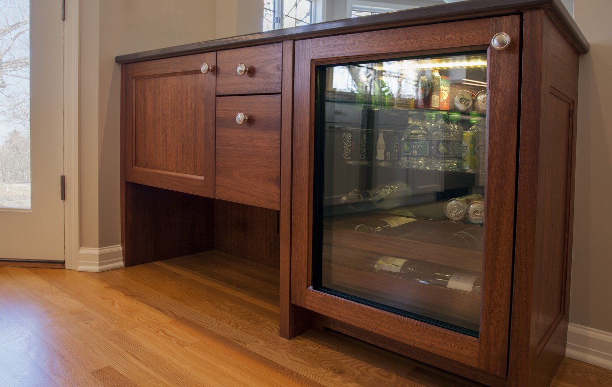 <p>A pass-through cabinet between the kitchen and dining room serves multiple functions in a compact space. A space underneath the bar creates room to kick off shoes when coming in from the patio.</p>
