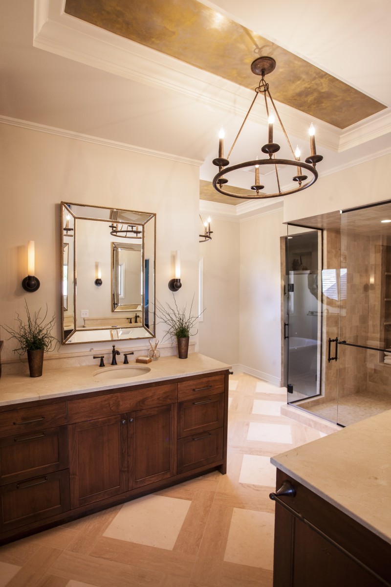 <p>Custom cabinets, marble countertops and travertine tile flooring, give this completely remodeled master suite an elegant feel. The space now has two generous vanities, a freestanding tub and an ample shower. Its cove ceilings are accented with metal gold venetian plaster and chandelier light fixtures.</p>
