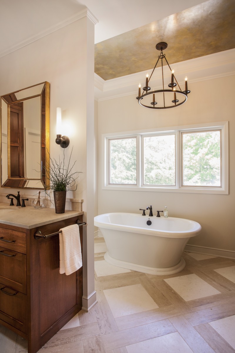 <p>Custom cabinets, marble countertops and travertine tile flooring, give this completely remodeled master suite an elegant feel. The space now has two generous vanities, a freestanding tub and an ample shower. Its cove ceilings are accented with metal gold venetian plaster and chandelier light fixtures.</p>

