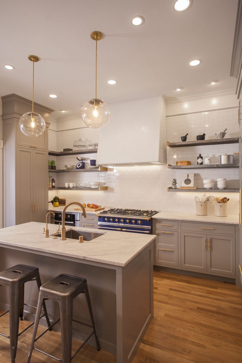 <p>Open cerused oak shelving and white subway tiles give the kitchen an open feel, while a handmade venetian plaster hood and custom brass shelf ends add an old-world feel to the space and accentuate the superb Lacanche stove.</p>
